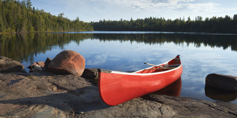 A canoe on the shore of a lake.