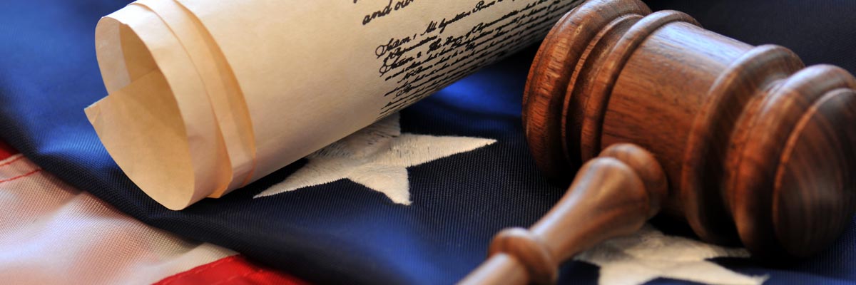 The U.S. Constitution and a gavel laying on top of the American Flag.